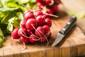 Fresh bundles of radish laid on a kitchen table photo