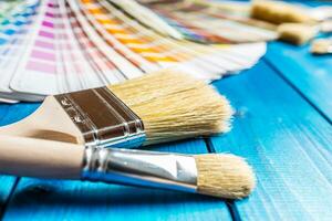 pintar latas color paleta, latas abrió con cepillos en azul mesa foto