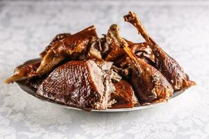 Portioned roast goose on a white plate - Close up photo