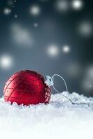 Christmas red Luxury ball in snow and abstract snowy atmosphere photo