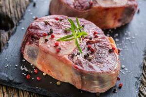 dos piezas crudo carne de vaca caña en pizarra tablero y de madera mesa. foto