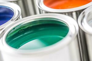 Full of multicolored paint cans on white table photo