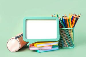 Pencil case,notebooks, colored pencils in jar and frame with space for text. Back to school concept photo