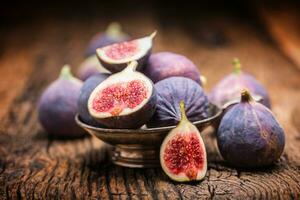 Figs. A few figs in a bowl on an old wooden background photo