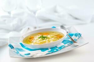 Lunch setting table with chicken or beef soup with noodles carrot and herbs photo