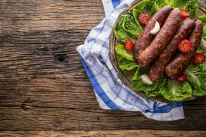 Sausages. Smoked Sausages. Chorizo sausages with vegetable rosemary spices and kitchen utensil. photo