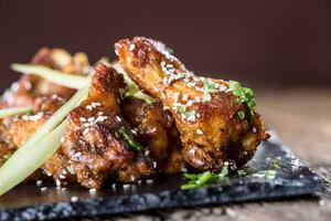 Chicken wings. Fried chicken wings in white bowl garlic dressing ketchup and potato fries. photo