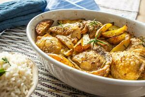 Chicken legs roasted with american potatoes in baking dish photo