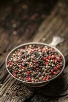 Mixed peppercorns red black and white in bowl - Close-up photo