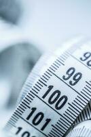 Curved measuring tape. Measuring tape of the tailor. Closeup view of white measuring tape photo