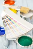 Paint cans brushes and color palette on table photo