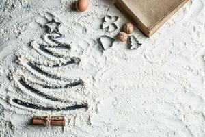 Shaped christmas tree of flour and old recipe book. photo