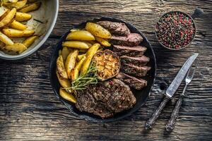 Grilled beef Rib Eye steak with garlic american potatoes rosemary salt and spices photo