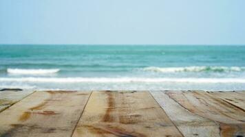 Wooden table top on blurred sea, waves and sky. Empty wooden table with summer sea waves on background.  Wooden table and sea , use for backgroud with space. photo