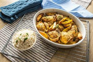 Chicken legs roasted with american potatoes in baking dish photo