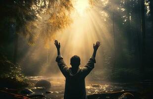 Man with raised hands, hit by rays of light. Religion concept photo