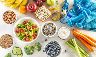 selección de sano alimentos, verduras, frutas, Almendras, ensalada, ejercicio herramientas y medición cinta foto