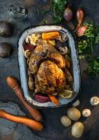 Whole chicken baked whole with vegetables in a retro roaster. photo