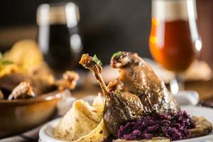 Roasted christmas duck leg red cabbage dumplings liver draft beer and baked buns photo