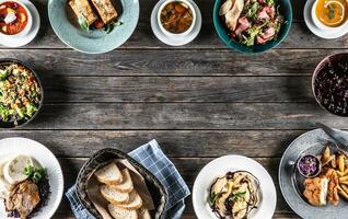 Top view of assortment of food served on a rustic wooden table with copy space photo