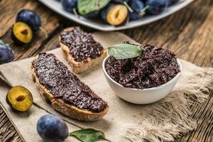 Breakfast from homemade plum jam bread and ripe plums. photo