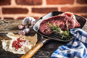 crudo carne de vaca filete en parrilla pan con sal pimienta ajo y hierbas en de madera mesa foto