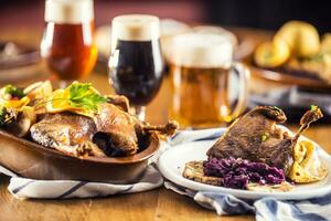 Roasted christmas duck leg red cabbage dumplings liver draft beer and baked buns photo