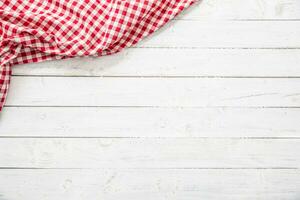 Red checkered kitchen tablecloth on wooden table. photo