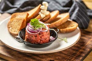 Beef tartare with red onion toast bread and garlic photo