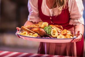 Woman holding garnished roasted duck in pub or restaurant photo