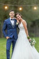 contento y confidente joven casado Pareja poses al aire libre después diciendo yo hacer a su Boda foto