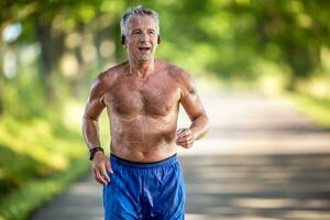 Very fit man in his 70s runs only in his shorts outdoors in the nature photo