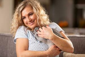 Blonde woman hugging a grey bunny in an emotional moment of love towards animals photo