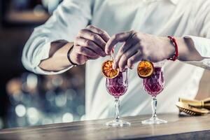 Barman in pub or restaurant  preparing a cocktail drink photo