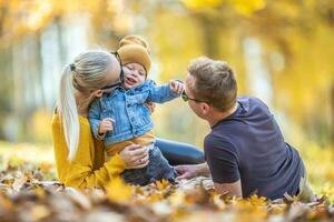 compartiendo amor y hora juntos por un joven familia en un otoño día foto