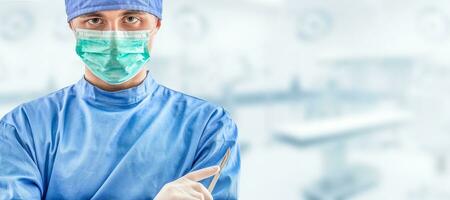 Young doctor surgeon specialist with scalpel. In the background blurred the interior of the operating room photo