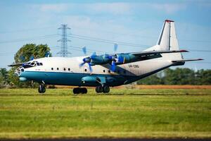 cavok aire antonov un-12 carga avión a aeropuerto delantal con marshaller aire carga y envío. aviación y aeronave. transporte industria. global internacional transporte. mosca y volador. foto