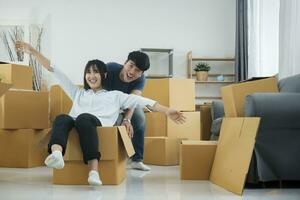 contento Pareja es teniendo divertido con cartulina cajas en nuevo casa a Moviente día. foto