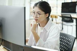 Young programmer working on desktop PC in office of software company. photo