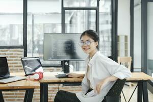 Young programmer working on desktop PC in office of software company. photo