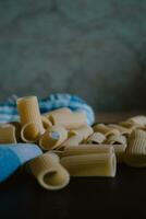 Delicious freshly made raw pasta prepared to be cooked. Fresh pasta on black slate background. photo