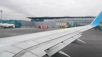 NOVOSIBIRSK, RUSSIA OCTOBER 02, 2022 - Airplane wing from the window. Aircraft of Pobeda airline at Tolmachevo airport. Flight departure, taxiing to the runway video