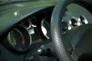 Car steering wheel and blurred cockpit in background photo