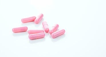Pink capsule pills on white background. Pharmaceutical industry. Vitamins, minerals, and supplements concept. Pharmacy products. Pharmaceutical medicine. Prescription drugs. Healthcare and medicine. photo