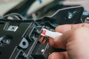 Mechanic replaces a fuse battery of motorcycle at garage. motorcycle maintenance and service and repair concept , selective focus. photo