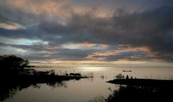 silhouette evening life with horizon by lake photo