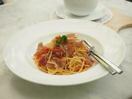 Spaghetti with Garlic, Dried Chili and Bacon in white plate, food photo