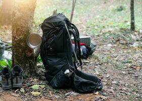 Backpack, shoes and bowl in mountains. Tourism hiking equipment photo