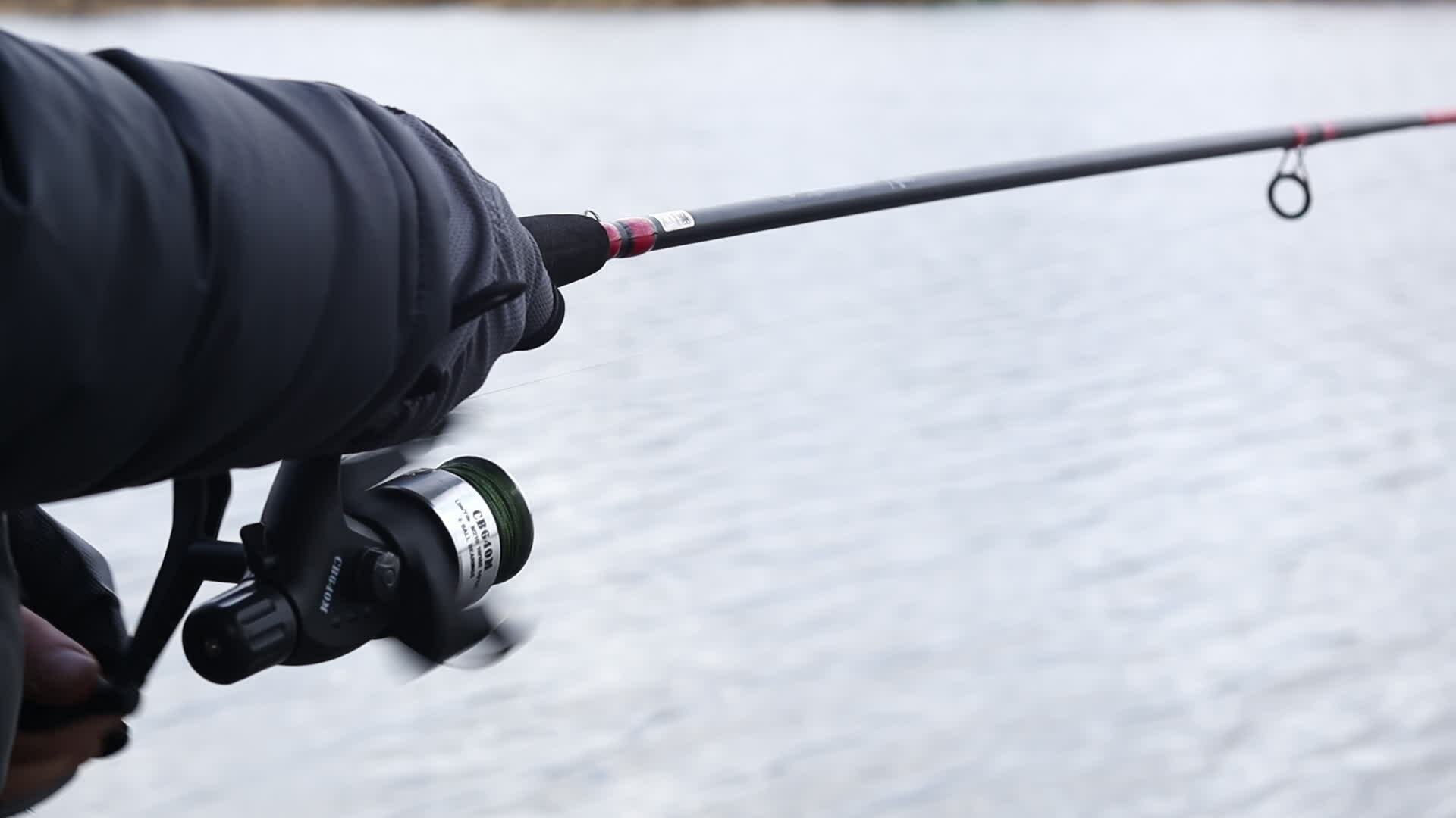 Hand spinning fishing rod reel, slow motion. A man fishes on a river or  lake, pulls a fishing line with a reel for fish. The concept of lifestyle,  outdoor recreation. Ukraine, Kyiv 