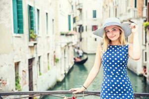 Happy young attractive woman fashion model of venice italy in blue polka dot outfit photo